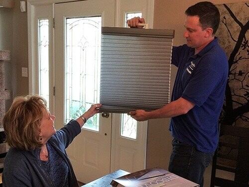 A Hang and Shine consultant showing a honeycomb shade sample to a customer in her home