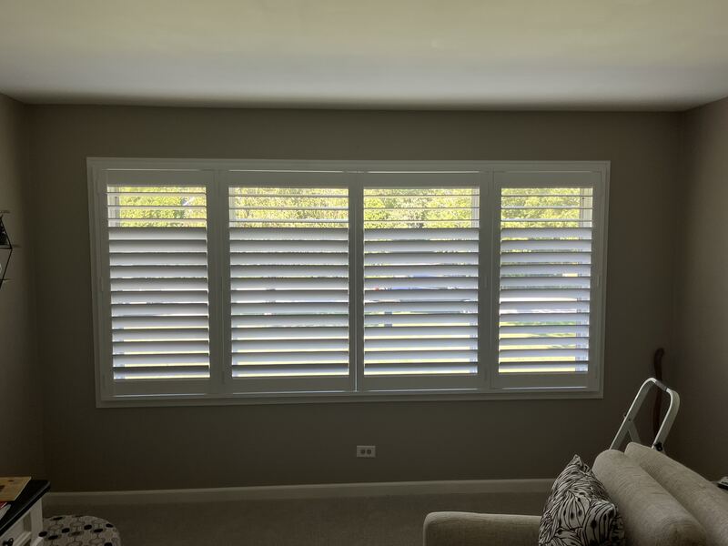 Four-panel Hunter Douglas plantation shutters across a wide picture window.